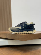 Moncler chunky sneakers with dark navy uppers, beige side panels, and rugged sole