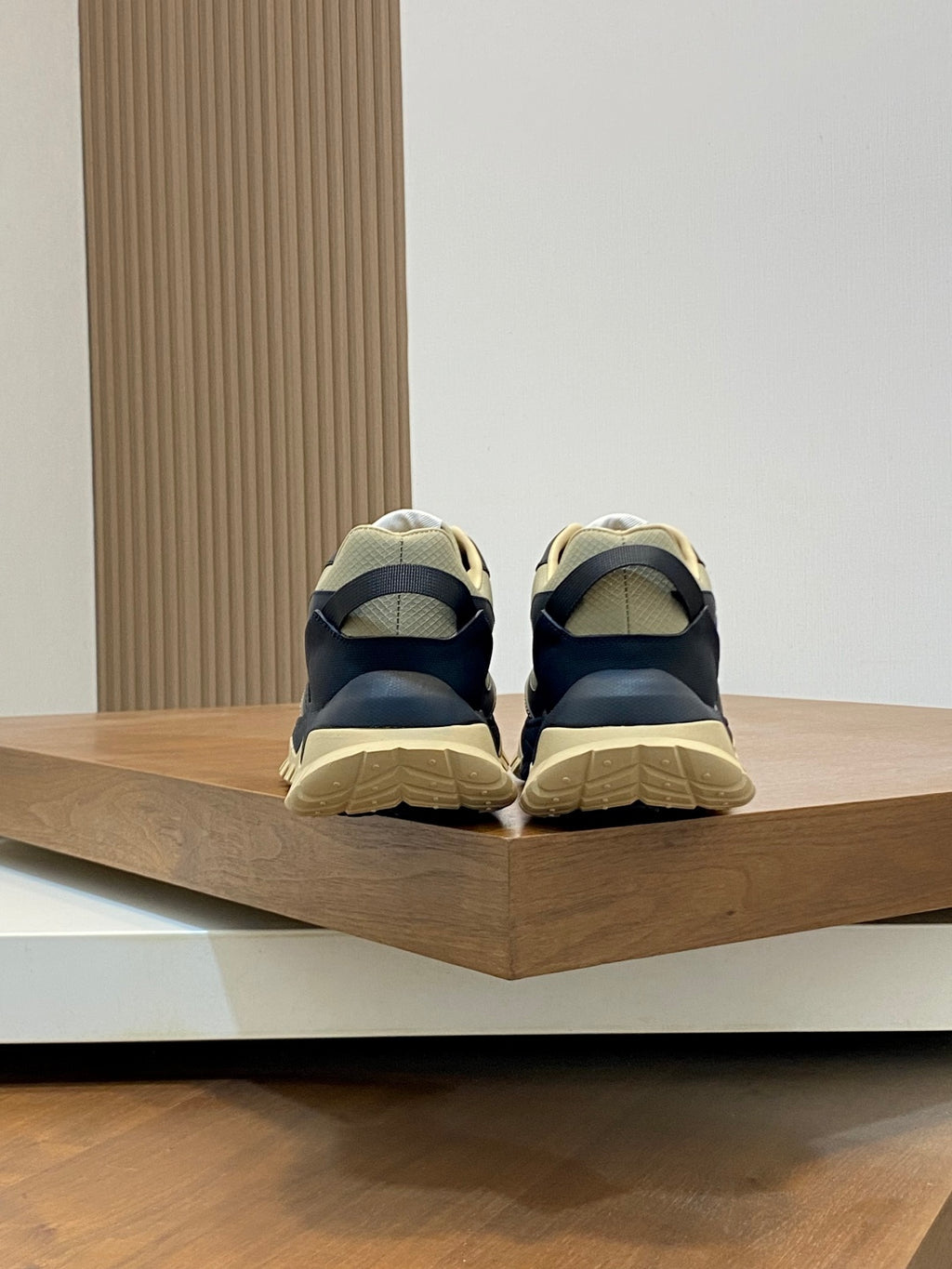Moncler sneakers from the back with dark navy uppers and beige rubber heel sole