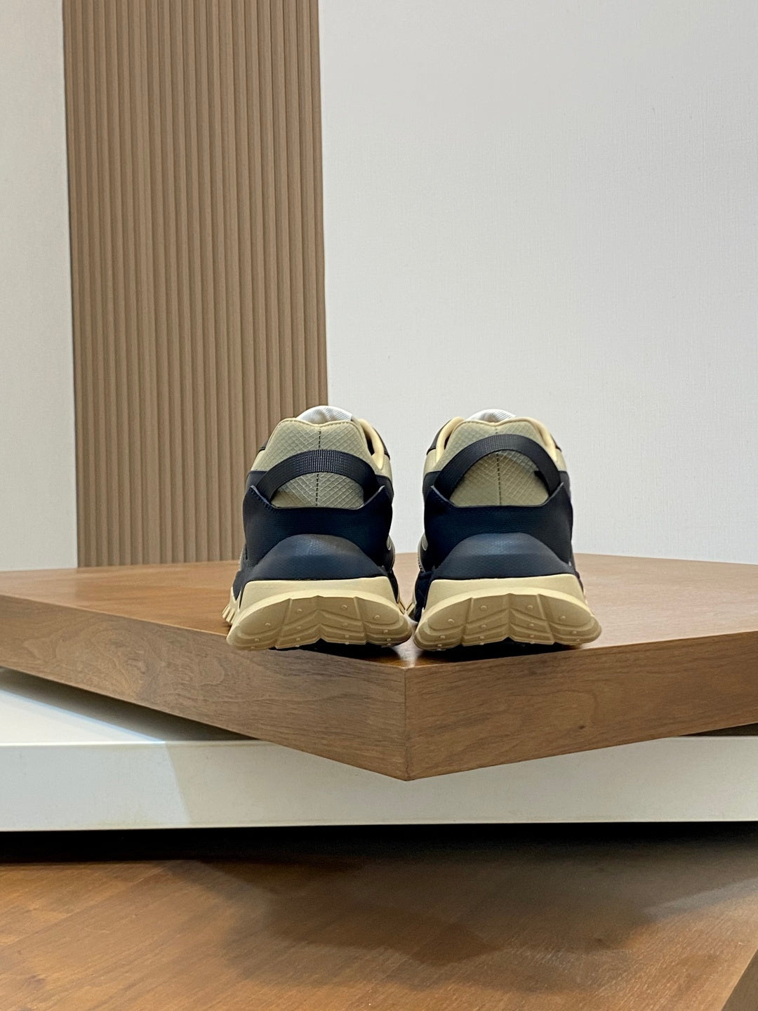 Moncler sneakers from the back with dark navy uppers and beige rubber heel sole