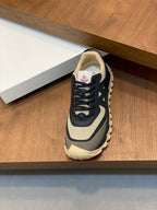 Moncler low-top sneaker with dark navy upper and beige trim on a display shelf