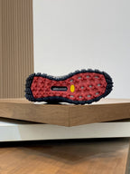 Moncler luxury shoe outsole with red tread, yellow center mark, and textured grip lugs