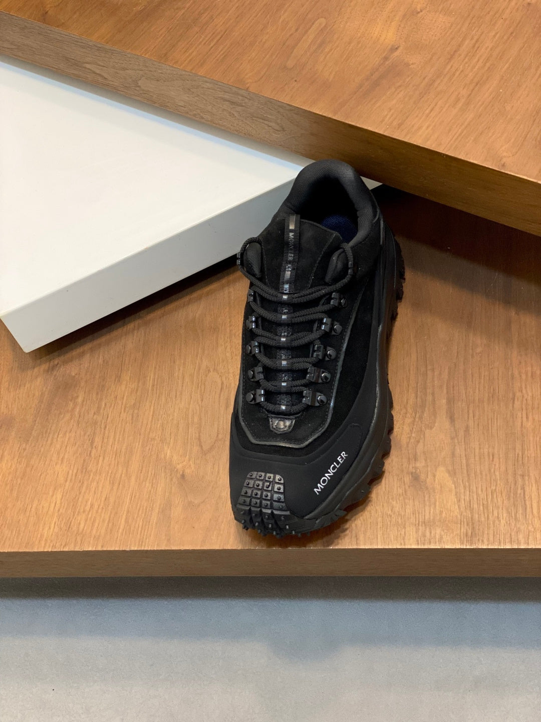 Moncler luxury lace-up shoe with dark upper, lace-up closure, and lug outsole