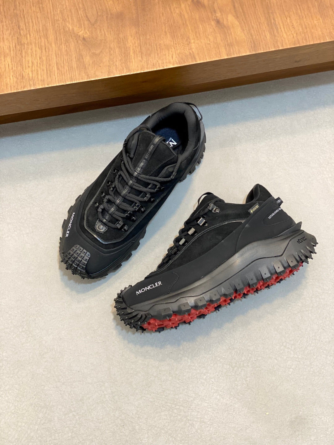 Moncler luxury lace-up shoes, dark upper with red-dotted outsole and side logo