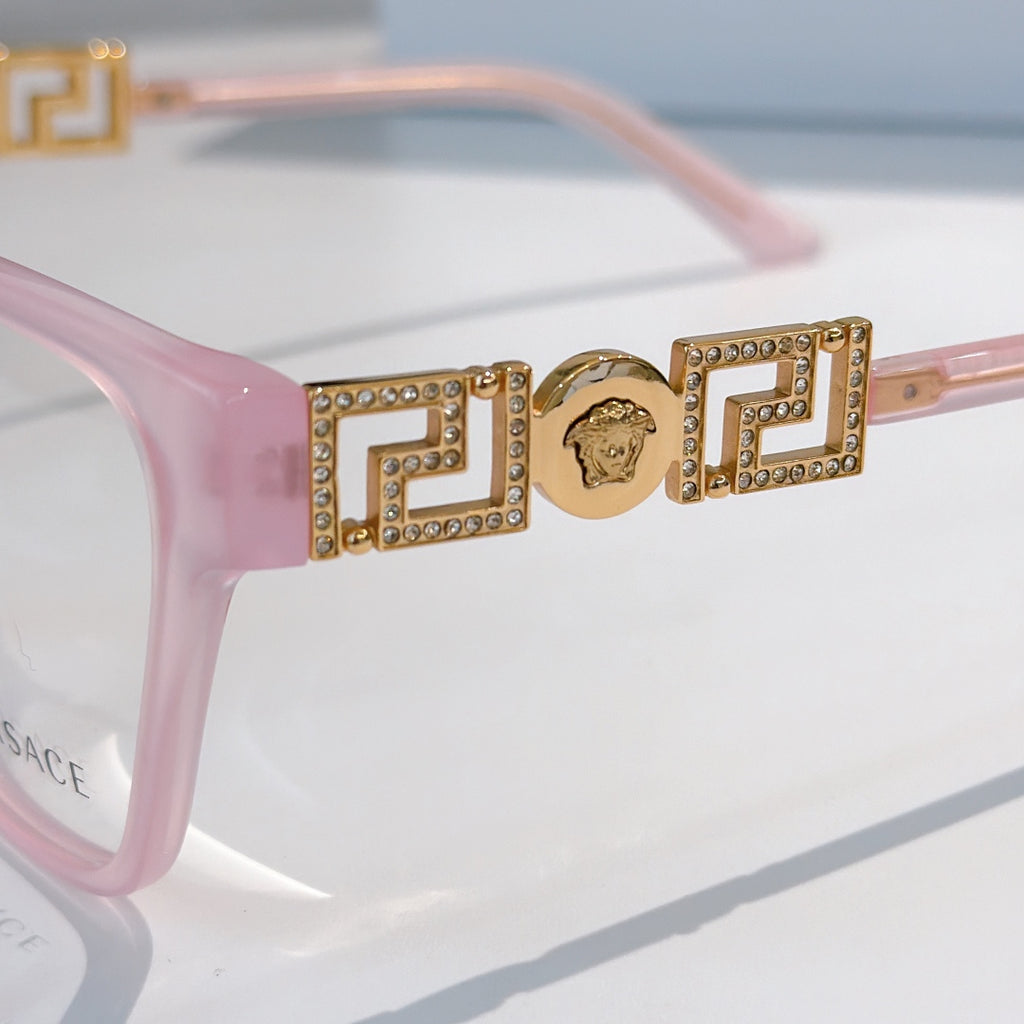 Pink eyeglasses temple with gold logo bar and rhinestone accents