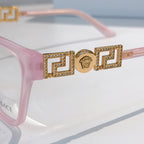 Pink eyeglasses temple with gold logo bar and rhinestone accents