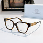 Tortoise square eyeglasses with gold temple logo detail and clear lenses
