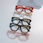 Assorted eyeglasses with red, clear, black, and pink frames and gold logo temples