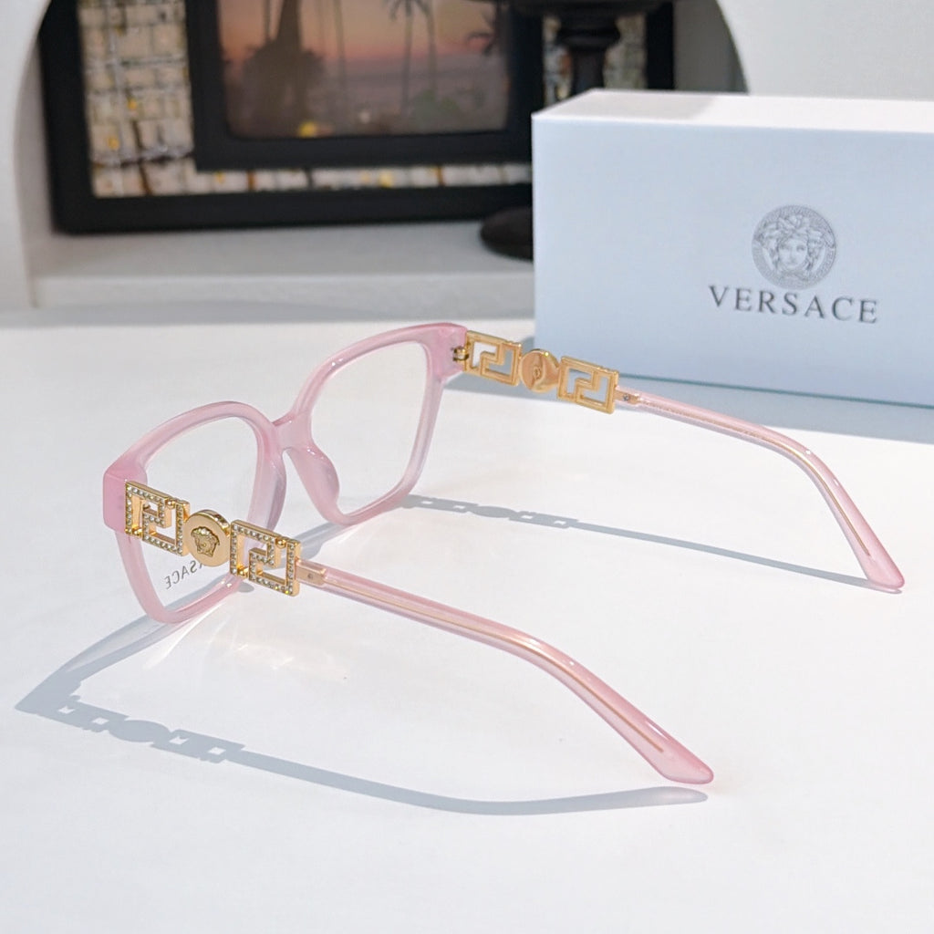 Pink eyeglasses with gold patterned temple detailing and clear lenses