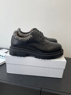Dior lace-up shoes in dark leather with patterned collar, side view on box