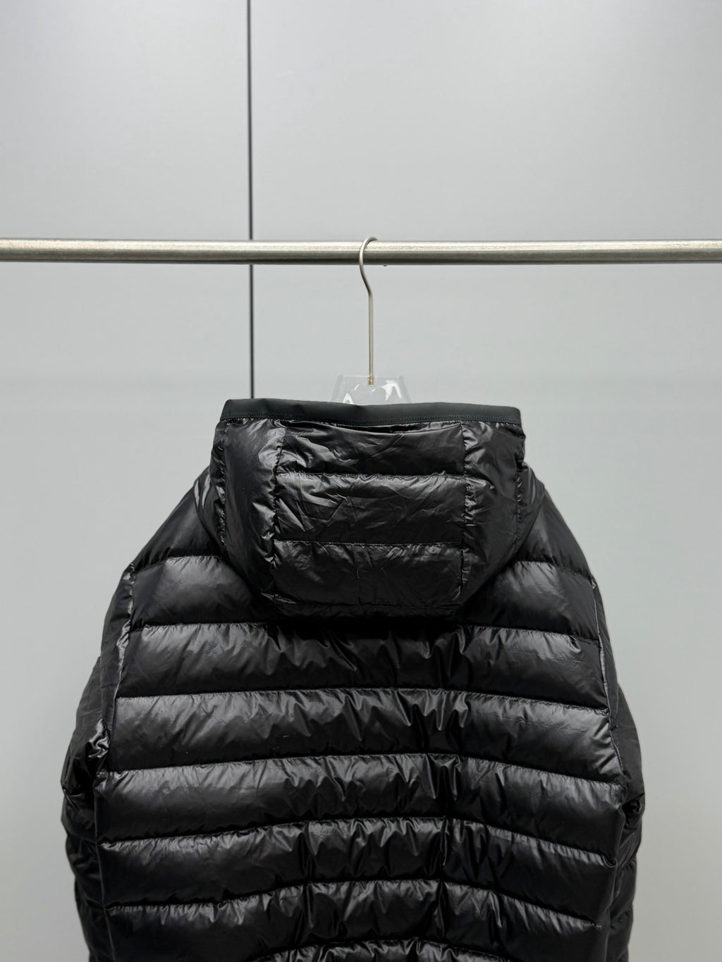 Long Moncler puffer jacket back view, black with hood and horizontal quilted panels