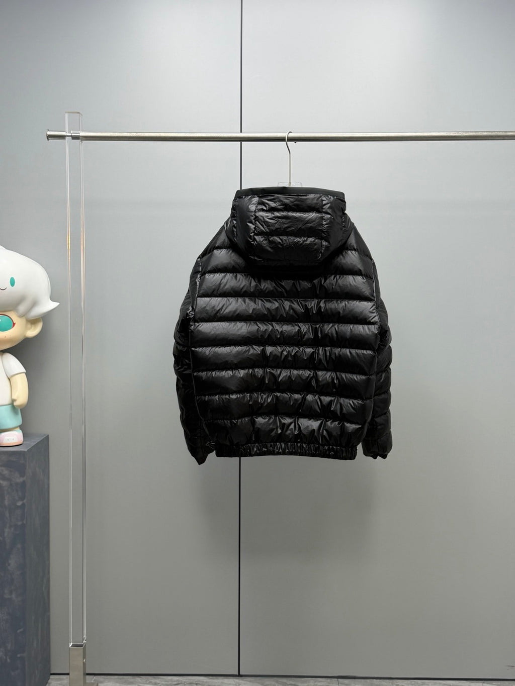 Long Moncler puffer jacket, black side view with hood and quilted body