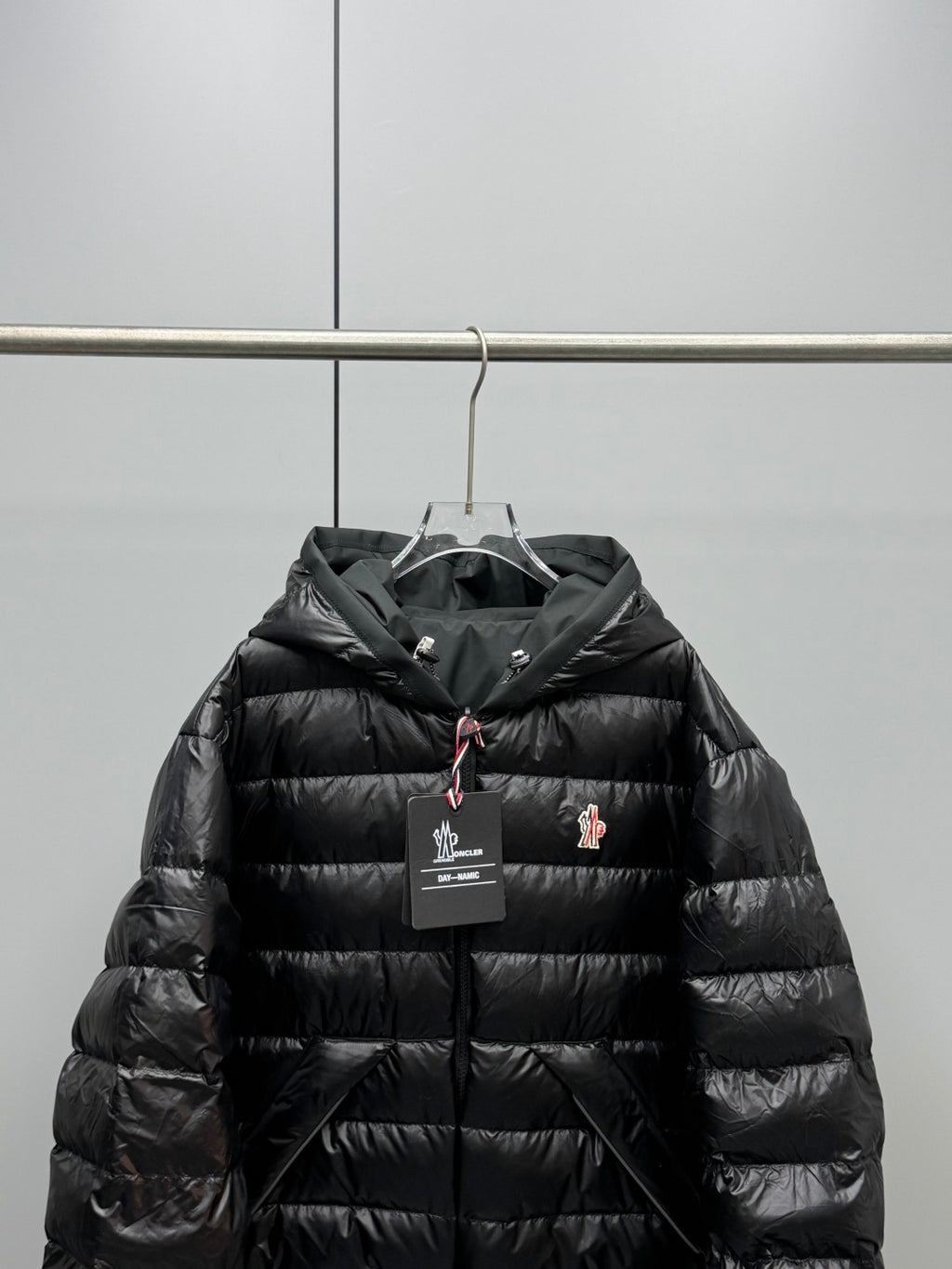 Long Moncler puffer jacket upper front detail, black with hood and zipper pull