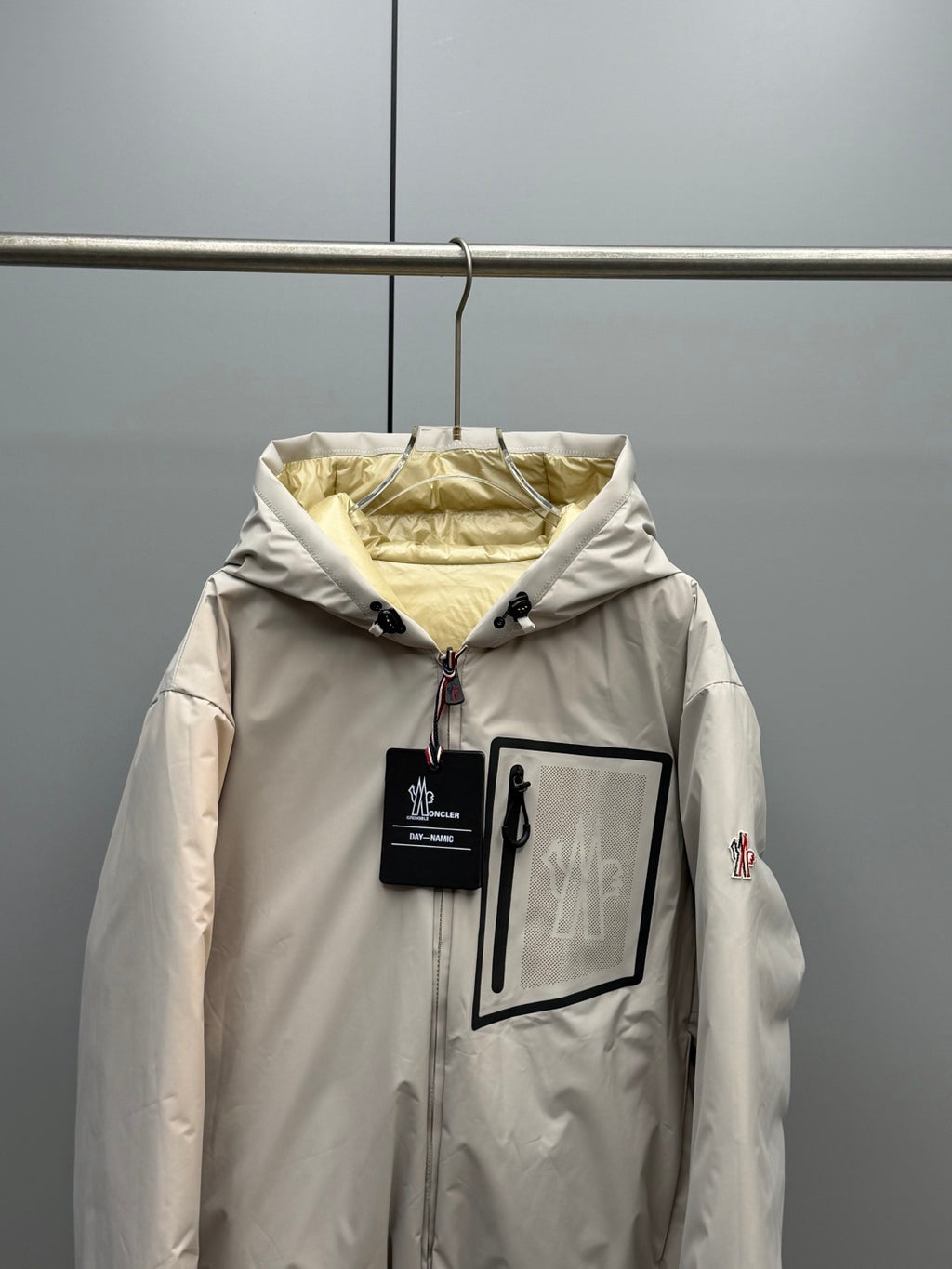 Light beige long zip-up puffer jacket with hood and front zip pocket detail