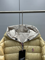 Long Moncler puffer jacket hood detail, light gold with white-lined interior