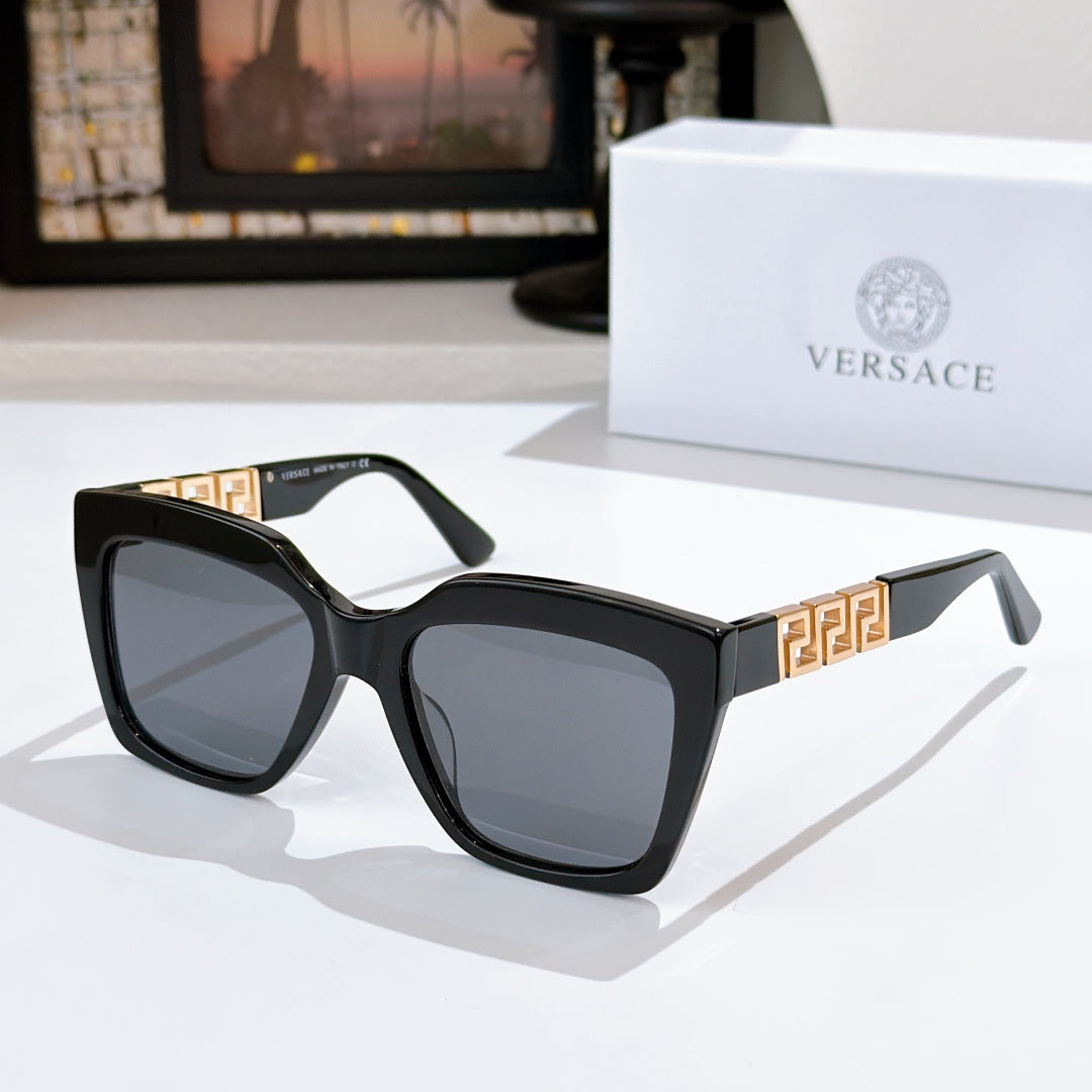 Black square sunglasses with gold temple emblem and dark tinted lenses