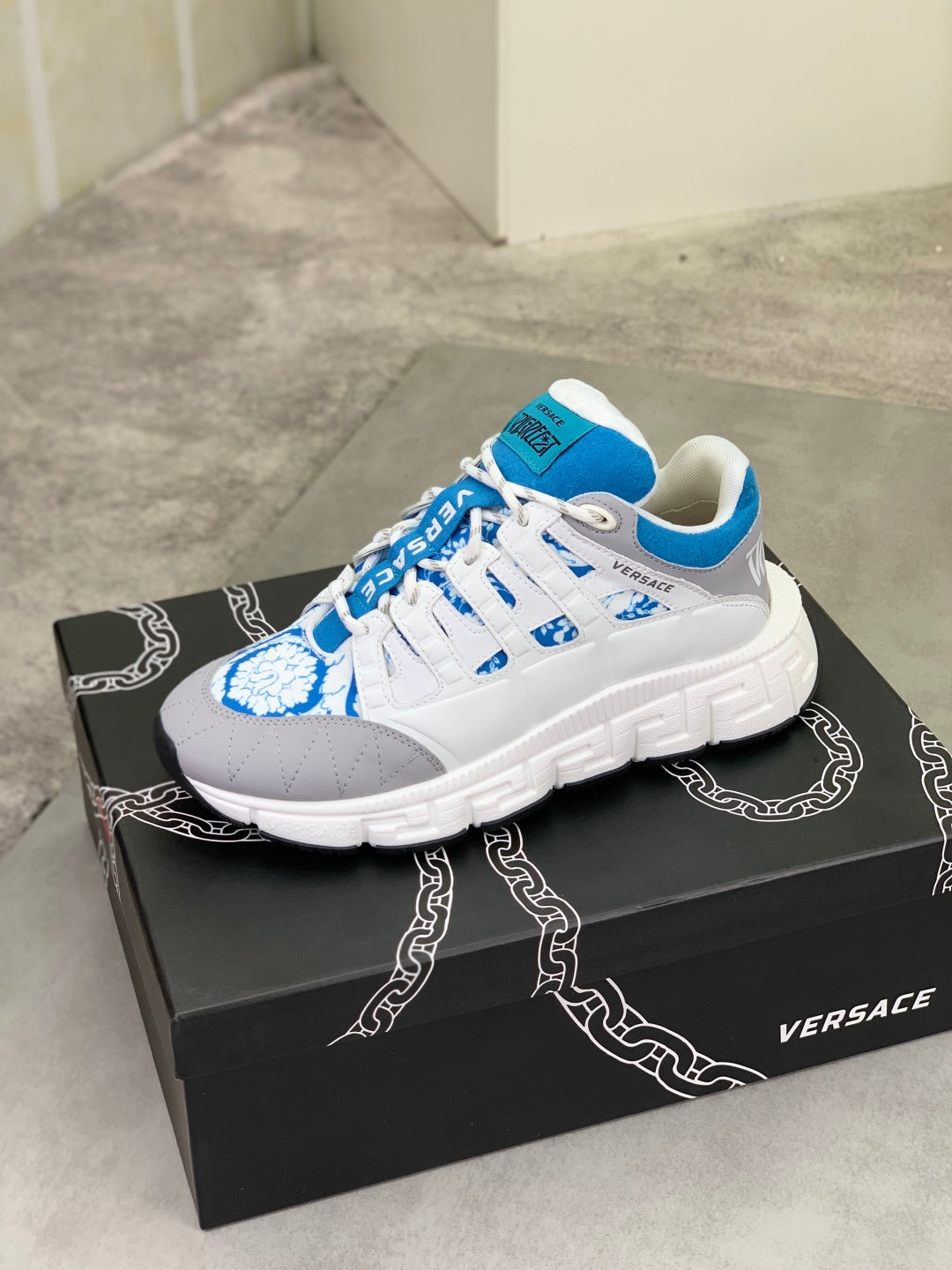 White and blue chunky lace-up sneakers with quilted side panels and logo on tongue.