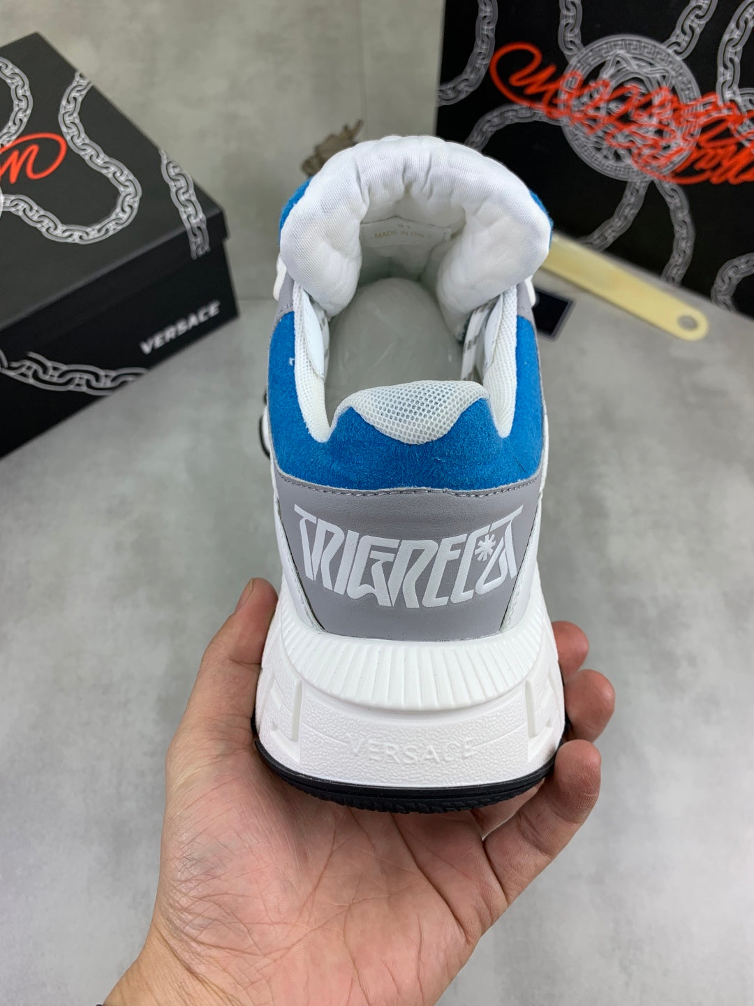 White and blue sneaker heel with blue collar lining and printed logo on back.