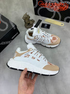 White and tan low-top sneakers with brown floral toe detail, pair view