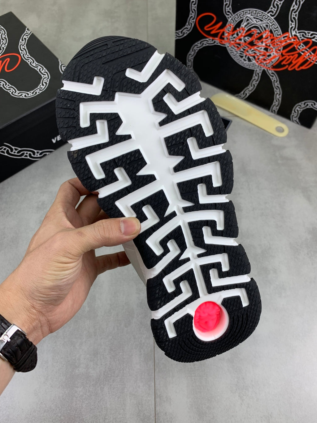 Black rubber outsole with bold white traction pattern and red circular center logo