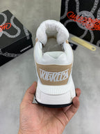 White and tan sneakers with padded collar and side branding on heel