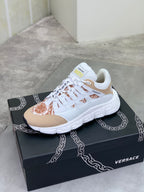 White and tan low-top sneakers with brown floral toe panel on black box