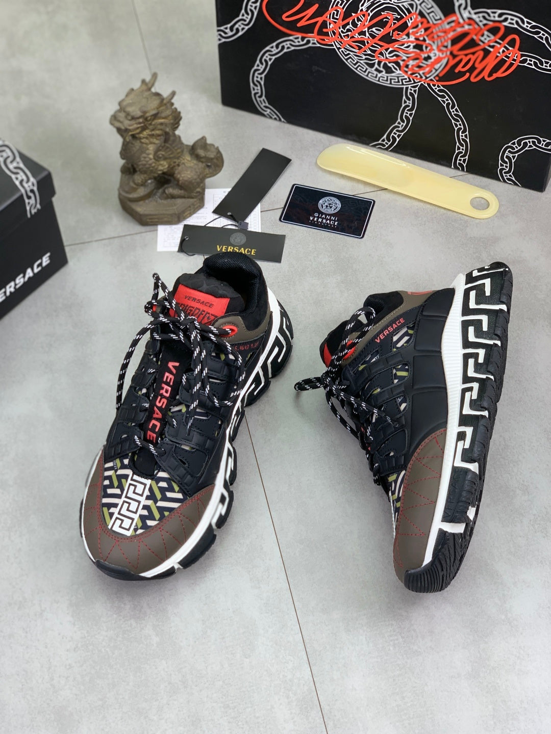 Versace lace-up sneakers in black with white Greek key side panels and red accents