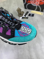 Versace sneakers close-up, turquoise suede-look side with purple graphic and black strap details