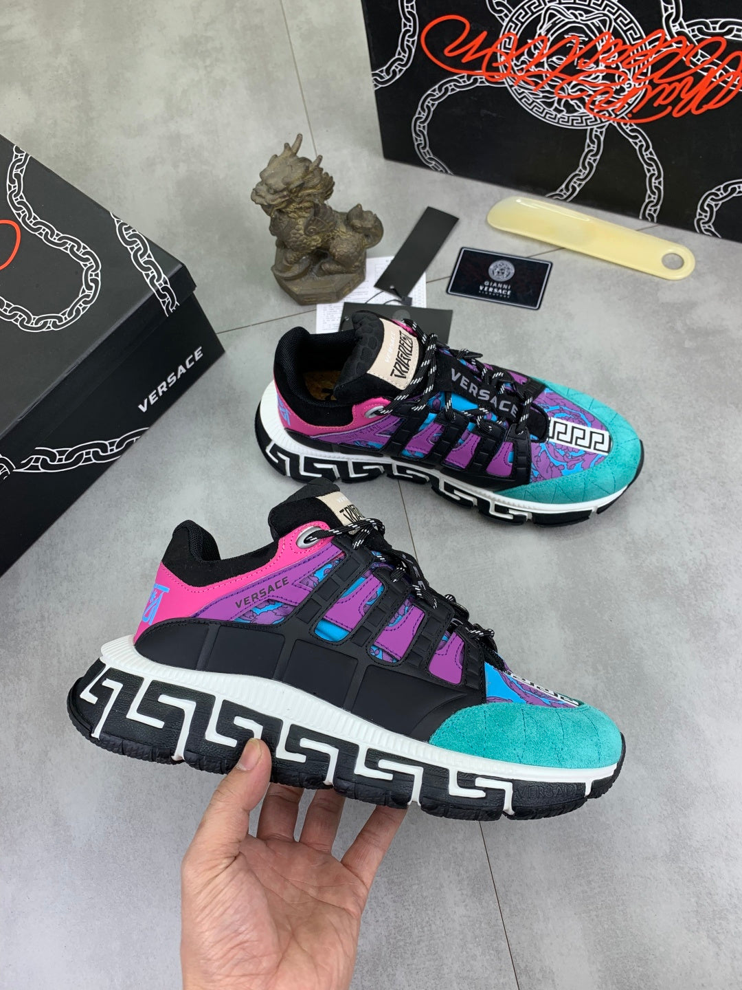 Versace sneakers pair, angled view with turquoise upper, purple accents, black laces and sole