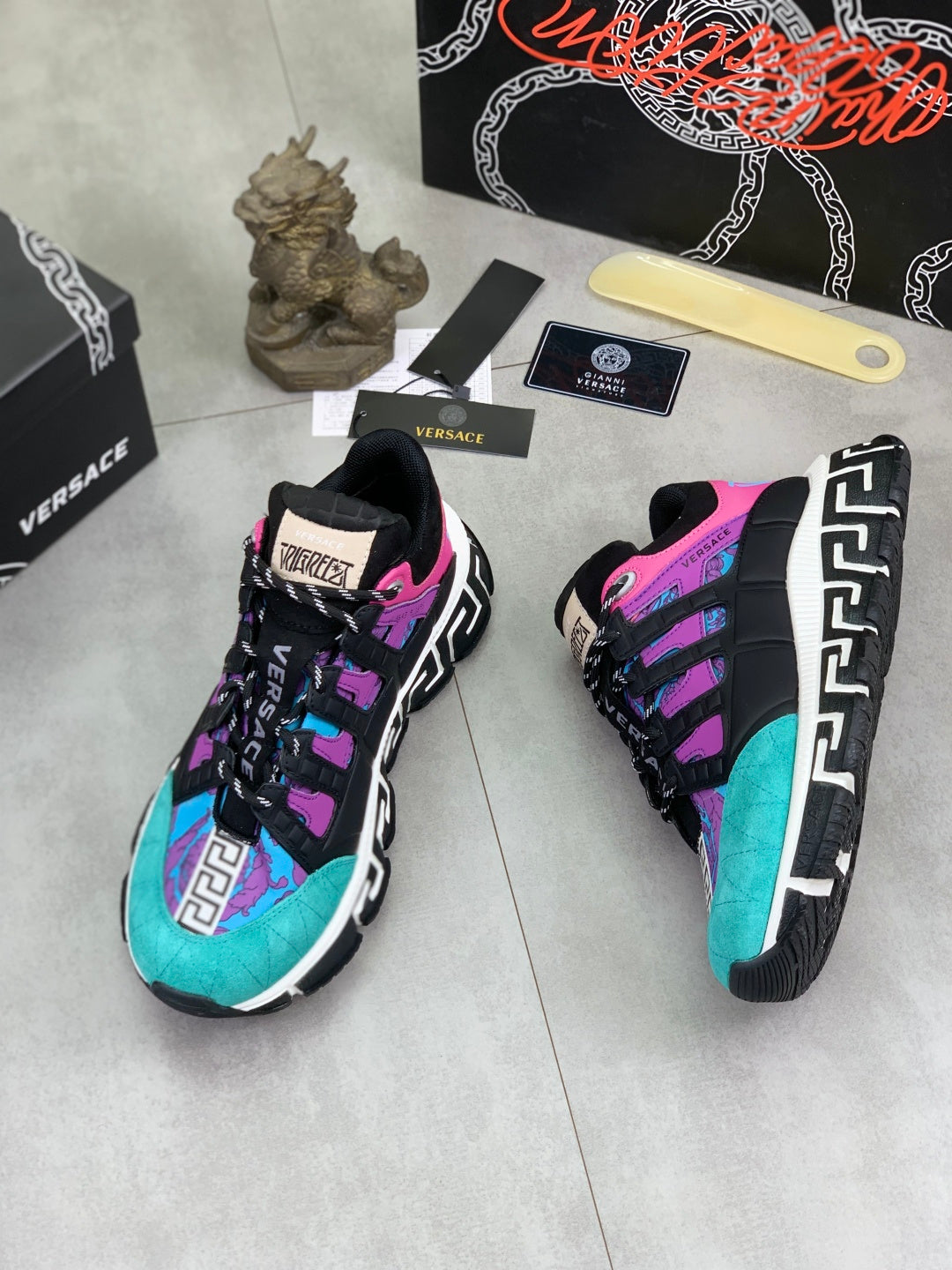 Versace sneakers side view, turquoise and purple upper with black laces and patterned sole