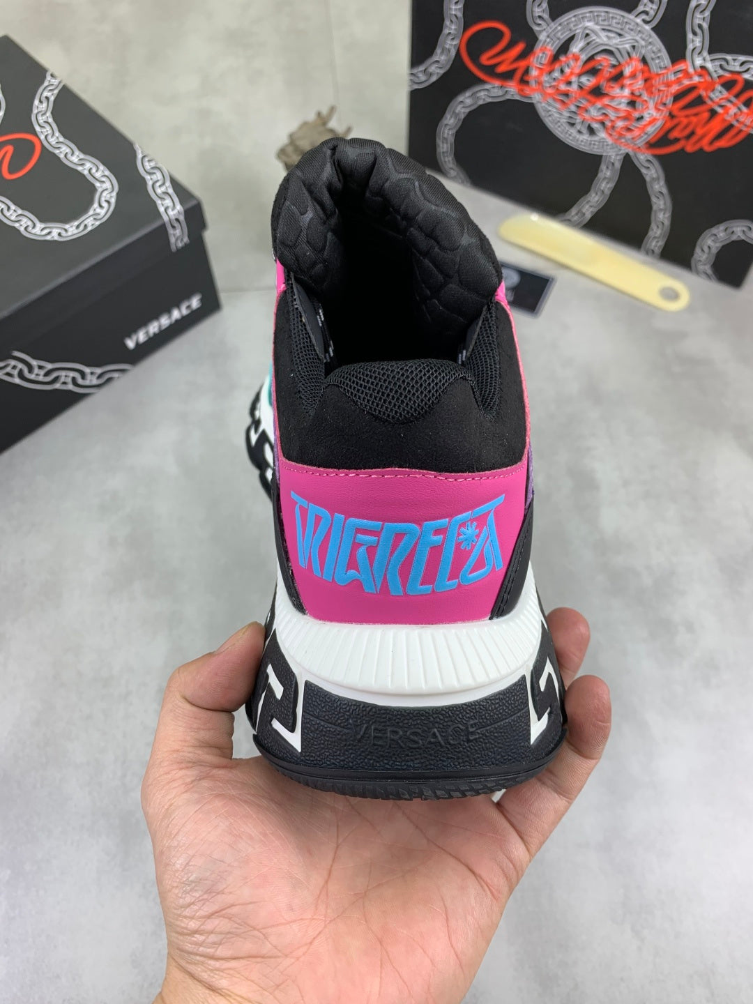 Versace sneakers back view, black upper with neon pink and blue graphic accents