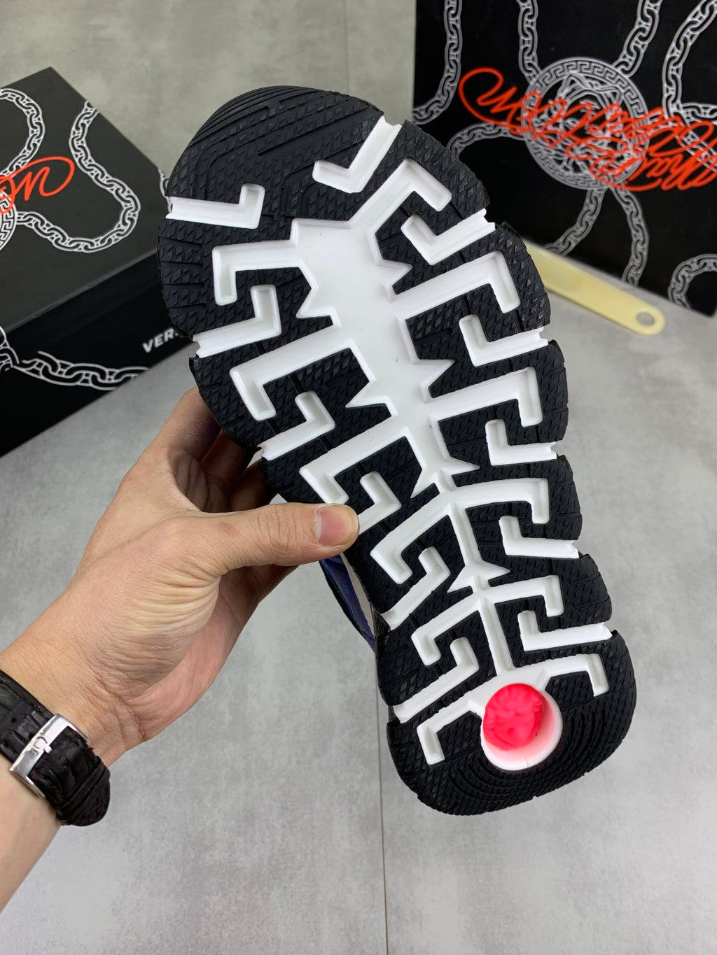 Versace sneaker outsole with white traction pattern and red circular grip detail