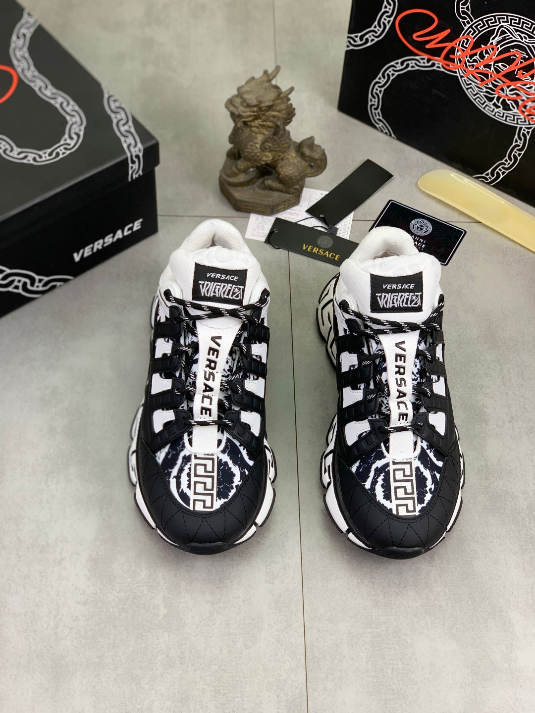 Pair of black and white low-top sneakers with white laces and bold logo panels
