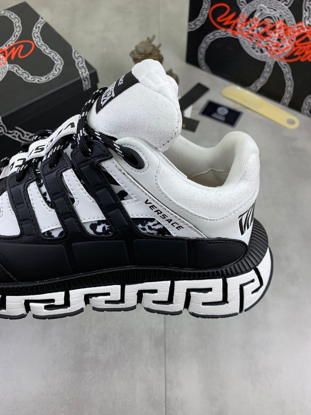 Black and white low-top sneakers with white toe cap, lace-up front, and patterned trim