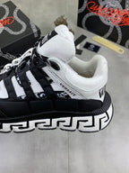 Black and white low-top sneakers with white toe cap, lace-up front, and patterned trim