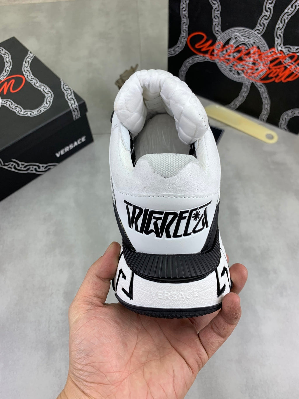 White sneaker heel with black logo text and black-and-white trim detail