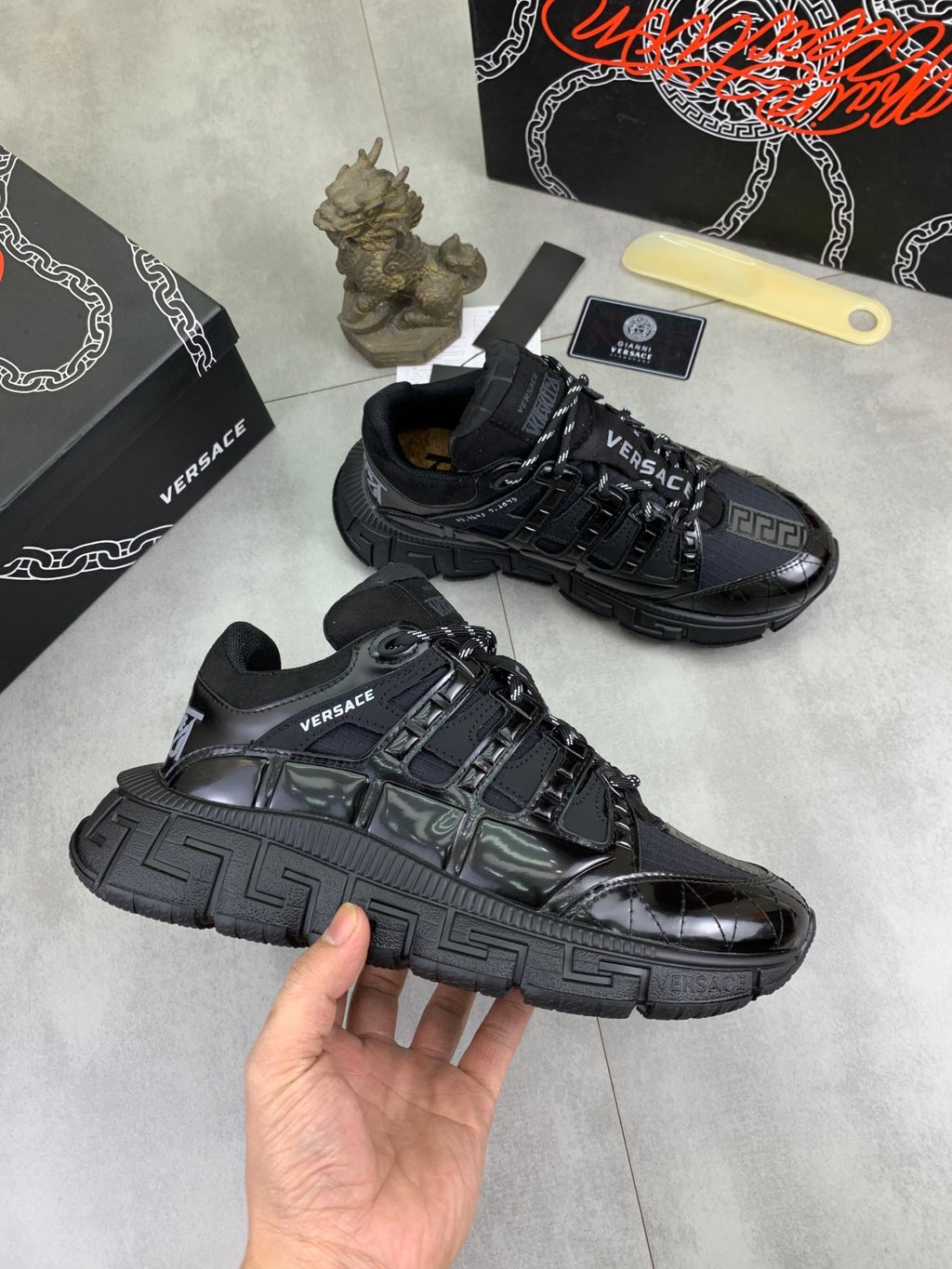 Versace luxury sneakers, angled view with black uppers and light accent panel details