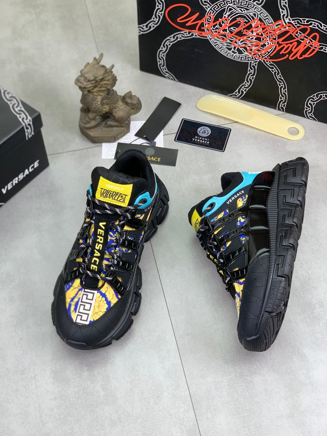 Versace black sneakers with blue accents and yellow patterned logo panel on side