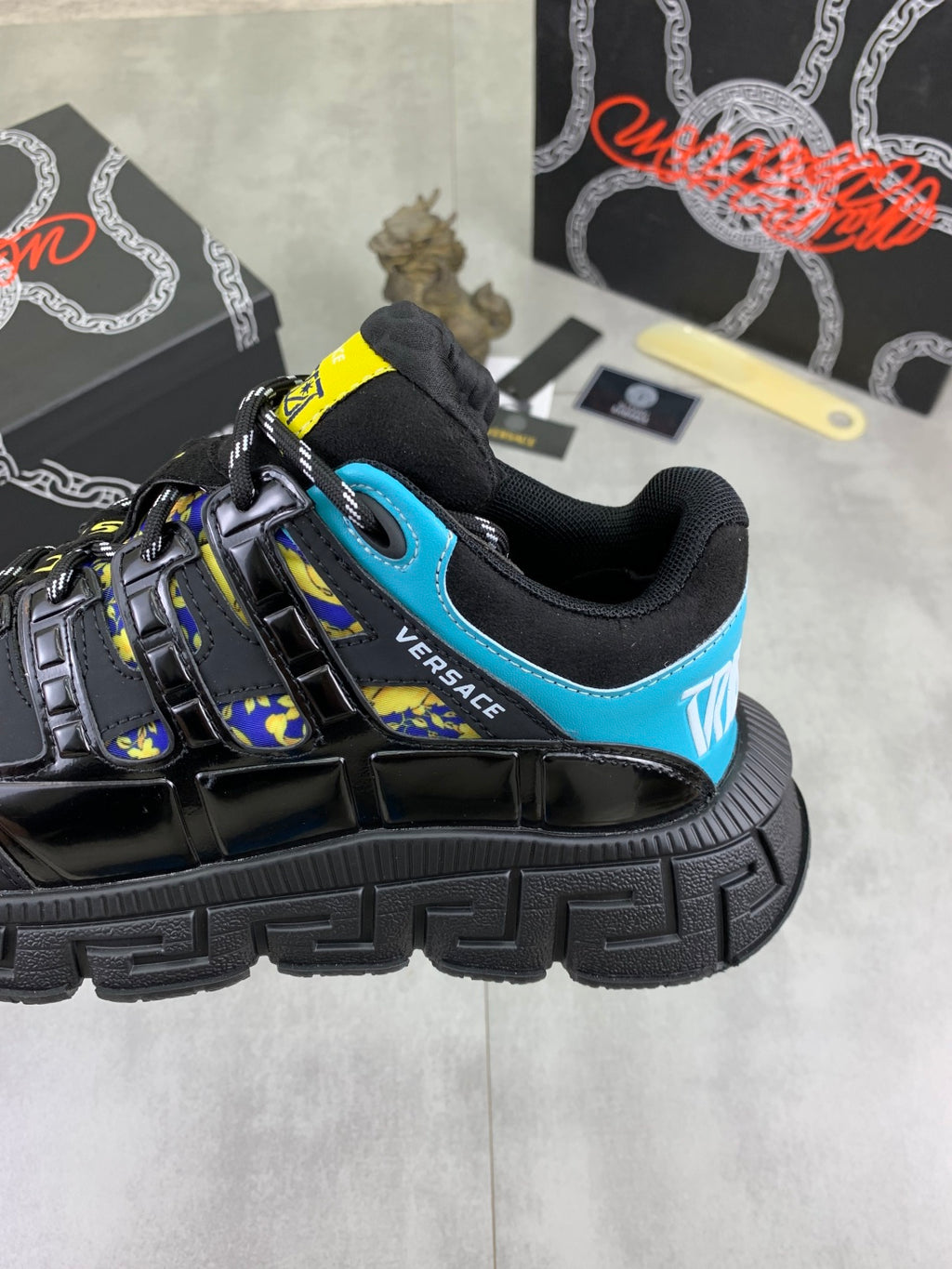 Versace black sneaker with bright blue collar and yellow-trimmed side graphic