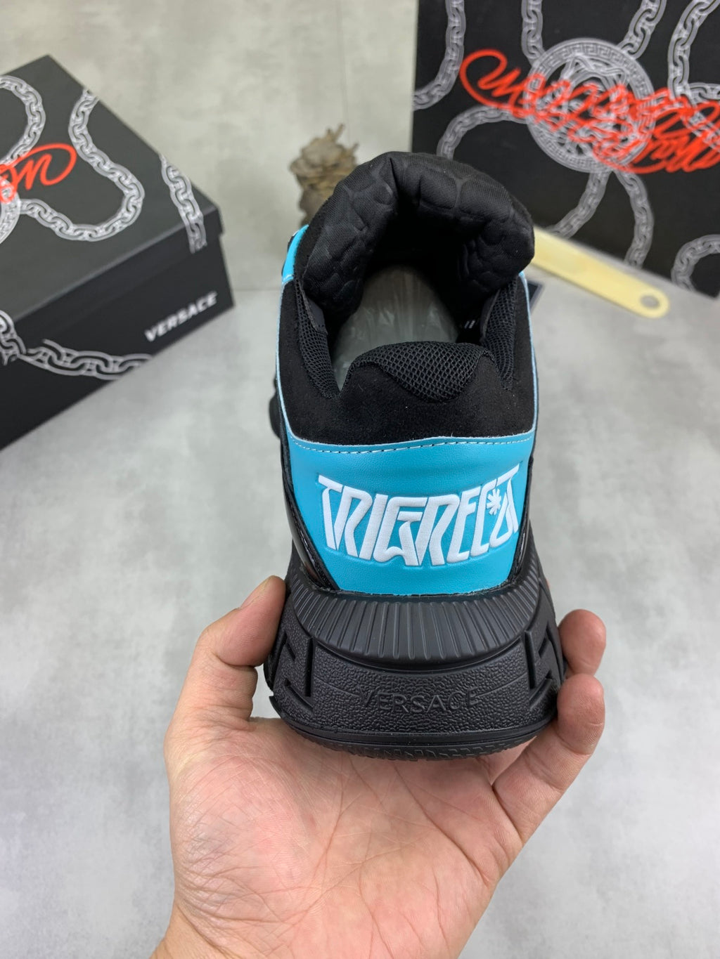 Sneaker heel view, black with turquoise trim and multicolor text patch