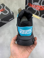 Sneaker heel view, black with turquoise trim and multicolor text patch
