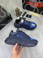 Versace blue lace-up sneakers, hand holds one pair, chunky textured sole