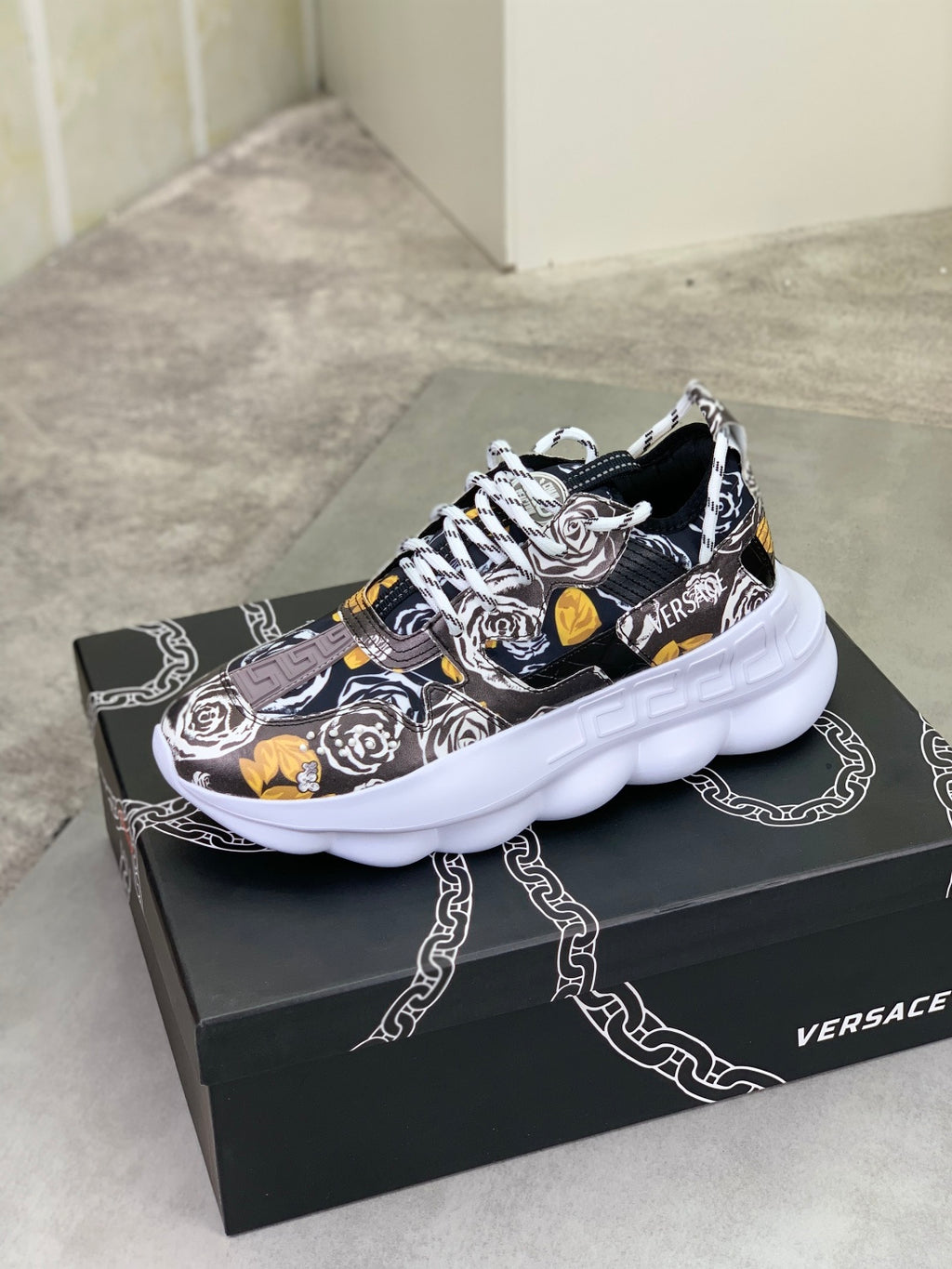 Printed lace-up sneakers with chunky white sole, black and white design with yellow accents.