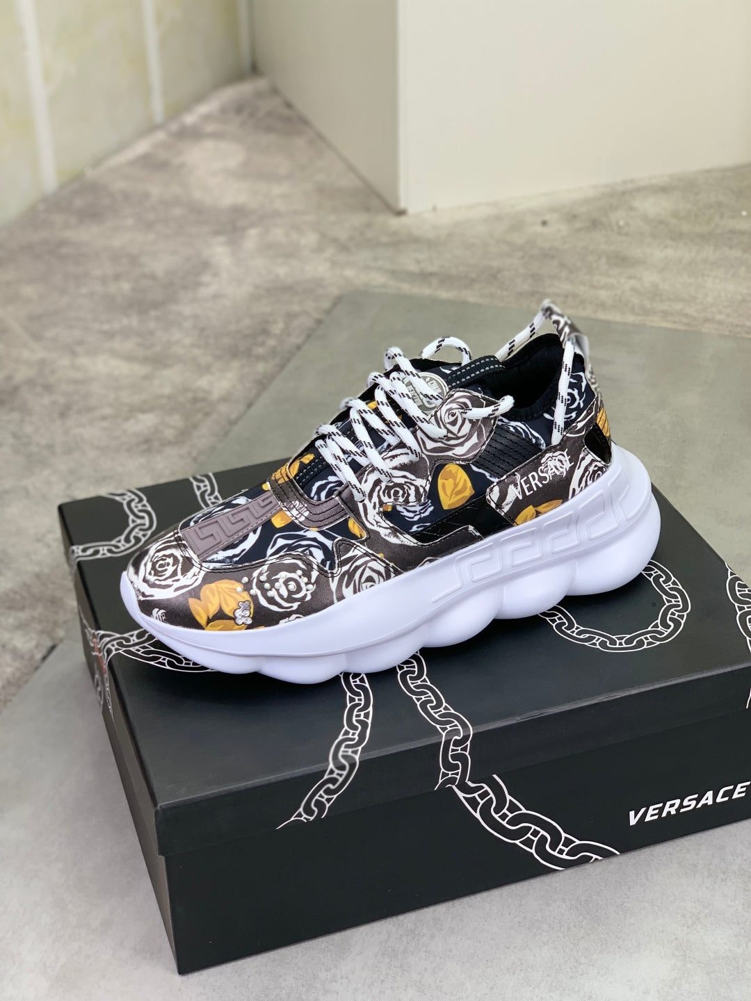 Printed lace-up sneakers with chunky white sole, black and white design with yellow accents.