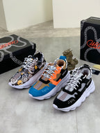 Pair of lace-up sneakers: one black-and-white printed, one blue with orange accents and white sole.