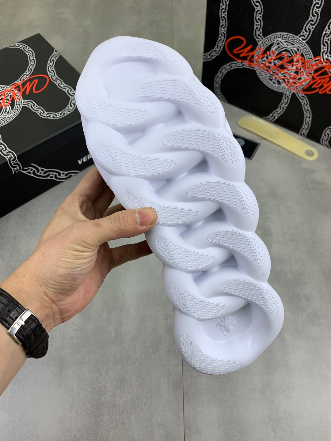 White sneaker outsole underside with textured tread and thick cushioned platform sole.