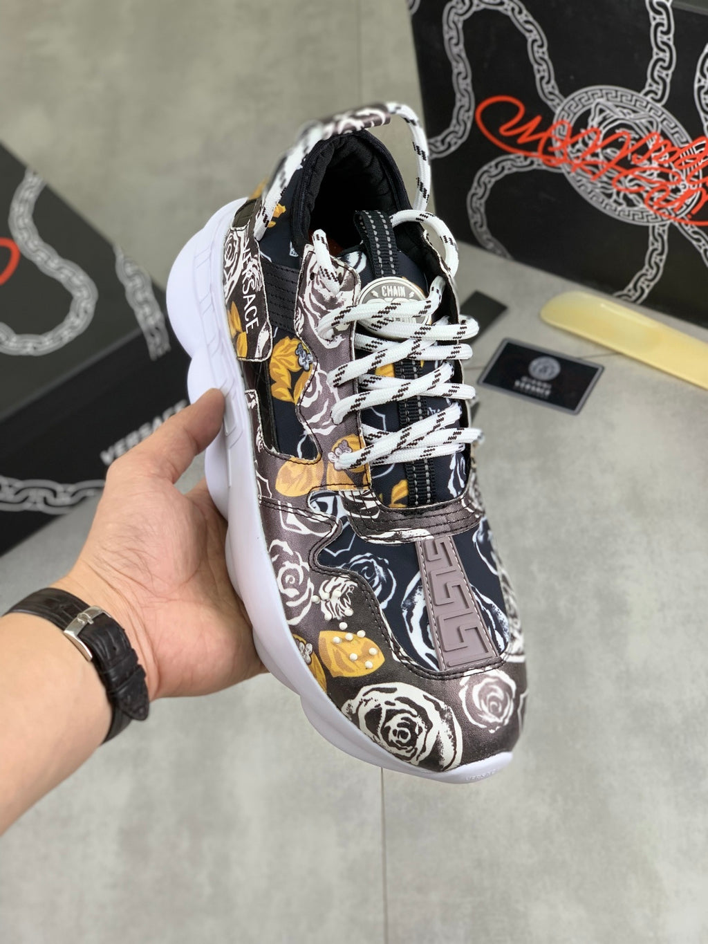 Versace printed sneakers, black with white roses and yellow accents, white sole.
