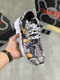 Versace printed sneakers, black with white roses and yellow accents, white sole.