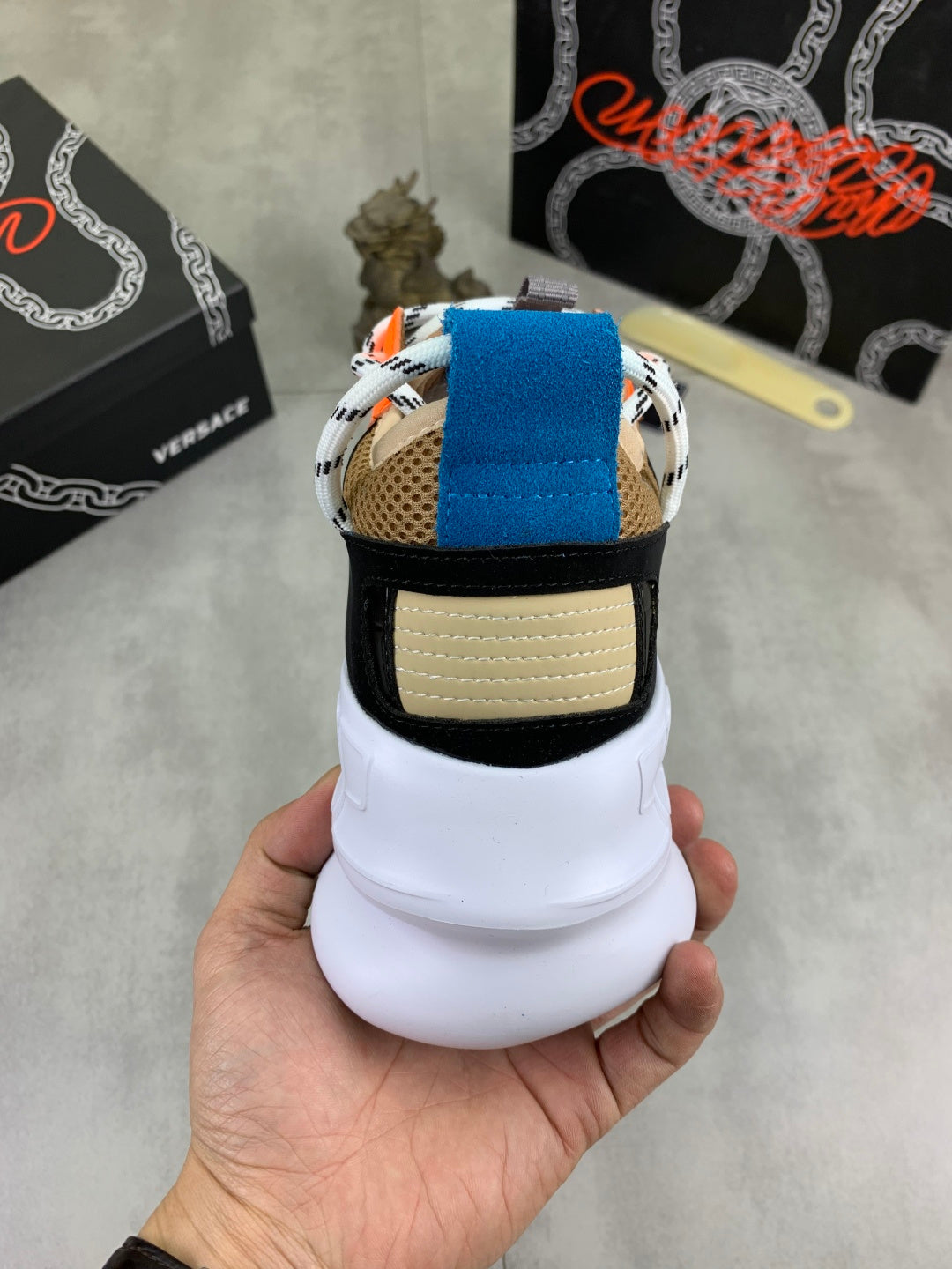 Versace sneakers heel view: white midsole, black and beige trim with blue strap