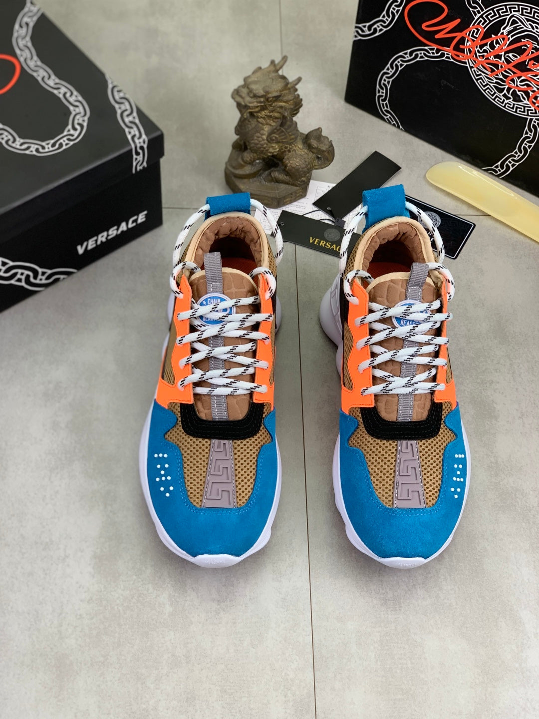 Pair of Versace sneakers in blue, orange, black, with white laces and beige lining