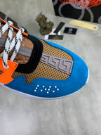 Versace sneaker toe panel close-up in blue suede with orange accents and textured mesh